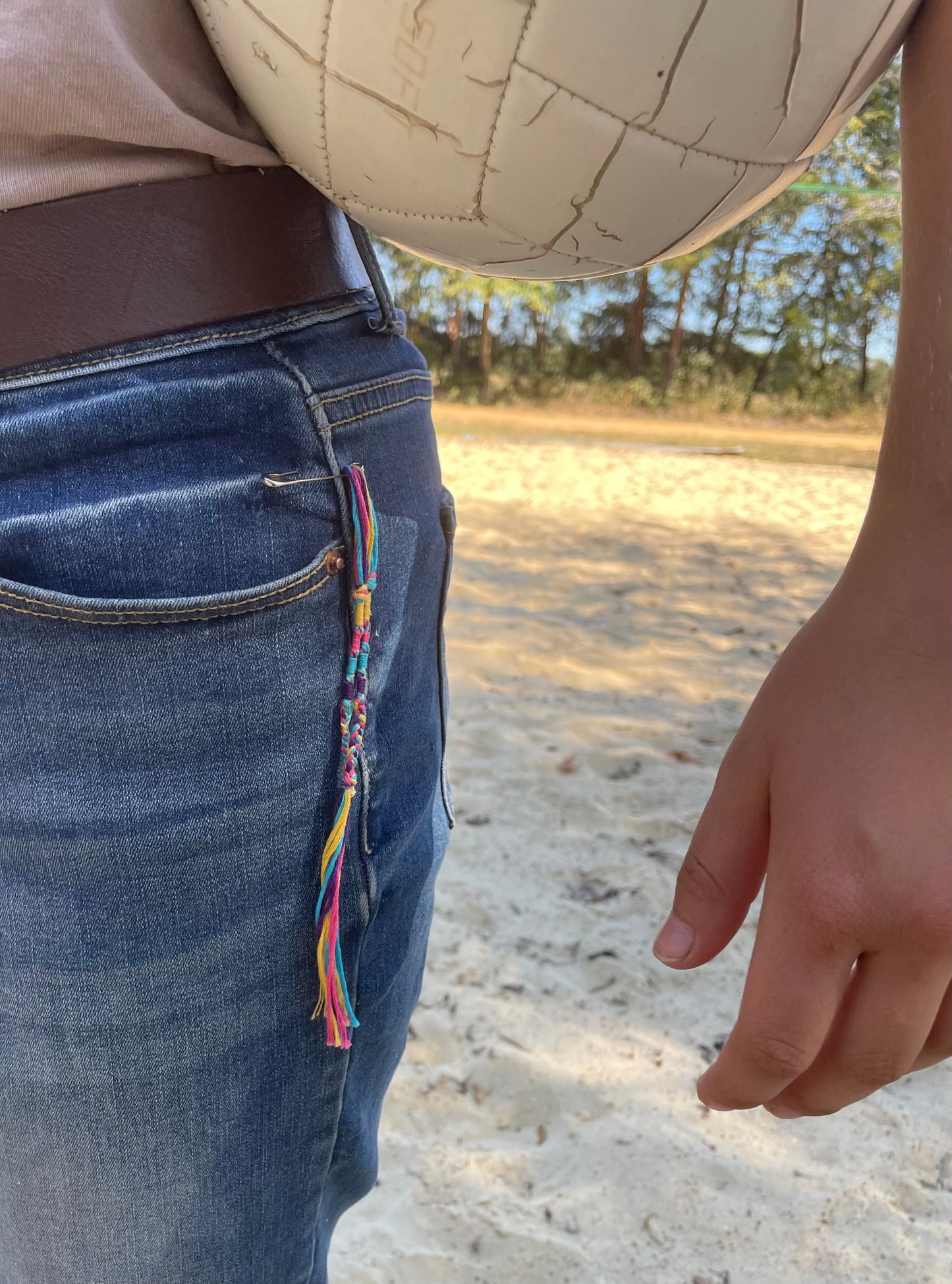 Hand-woven 100% cotton multi-colored tassels display up close on jeans by The Family of Yah