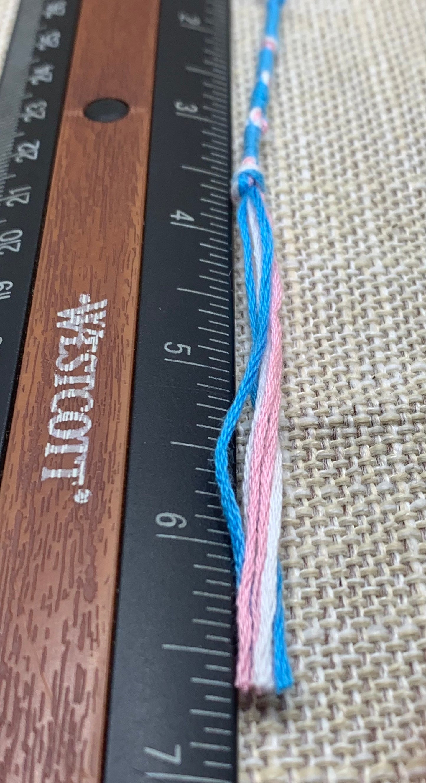 Close-up of blue and pink cotton tassel with blue cord detail