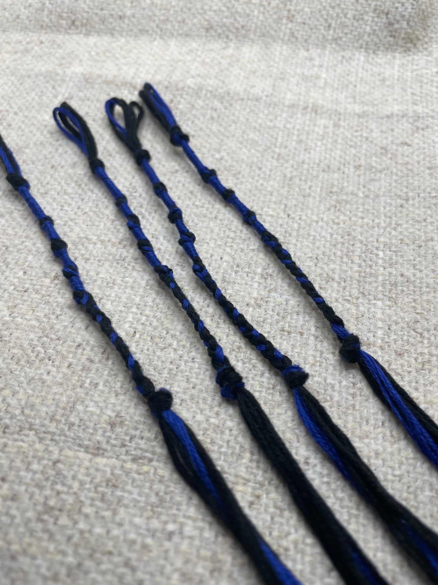 Set of four blue & black tzit-zit tassels displayed flat