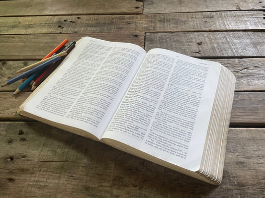 Open Scripture on Table with a couple writing utensils